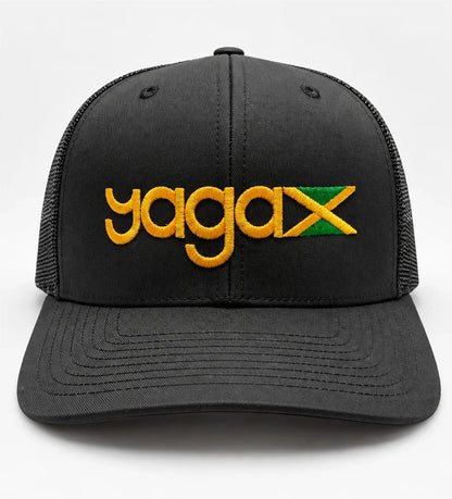 Front view of the black YAGA Jamaican Roots Trucker Hat with gold YAGA logo embroidery and an embroidered Jamaican flag above the curved brim.