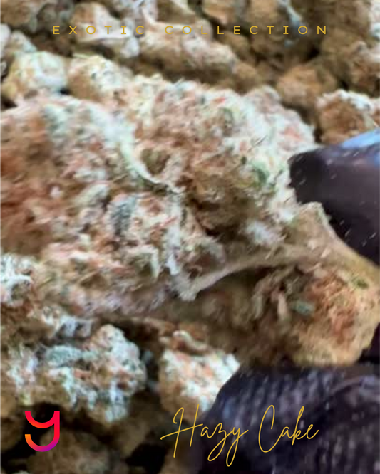 Close-up of YAGA Farms Hazy Cake cannabis bud showing dense structure, frosty trichomes, orange pistils, and shades of lime green and lavender, representing its premium indoor cultivation and 28% THCa content.
