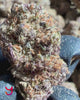 Close-up video of YAGA Farms Citrus Berry Gas buds showing deep green and rich purple hues, dense trichome coverage, and vibrant orange pistils.